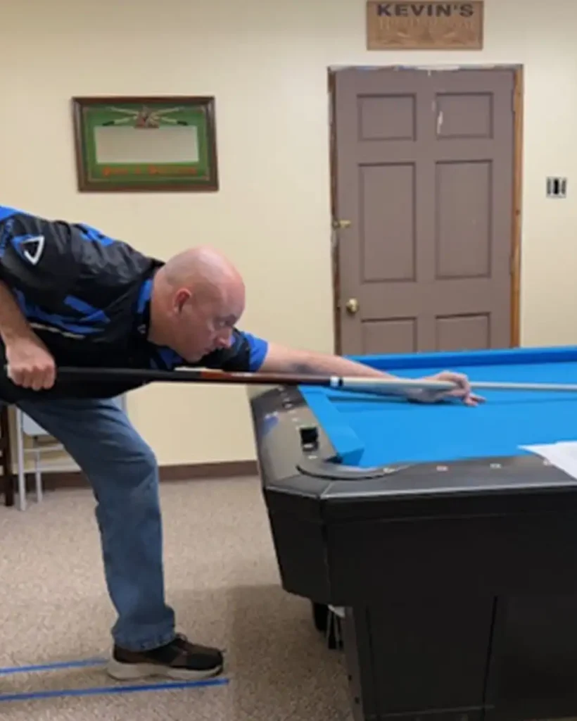 Billiards coach demonstrating pool technique during a lesson in Birmingham, Alabama